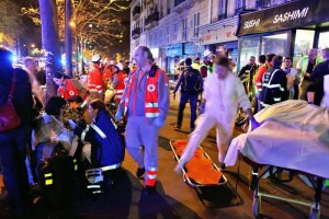 People rest on a bench after being evacuated from the Bataclan theater after a shooting in Paris, Saturday, Nov. 14, 2015. A series of attacks targeting young concert-goers, soccer fans and Parisians enjoying a Friday night out at popular nightspots killed over 100 people in the deadliest violence to strike France since World War II. (ANSA/AP Photo/Thibault Camus)